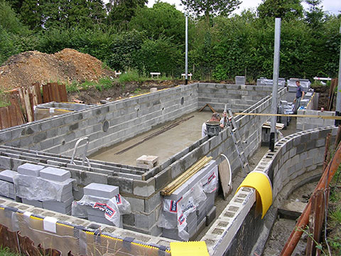 Photograph showing the blocks laid for the pool wall and cavity which will contain steel reinforcement and fittings (skimmers and inlet pipes)